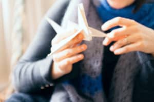 woman holding up an origami crane